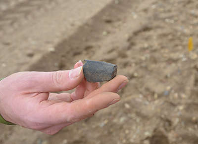 hand holding grey pottery